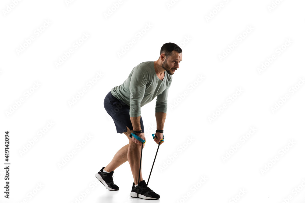 Jumping-rope. Young caucasian male model in action, motion on white background with copyspace. Concept of sport, movement, energy and dynamic, healthy lifestyle. Training, practicing. Authentic. Jumping-rope. Young caucasian male model in action, motion on white background with copyspace. Concept of sport, movement, energy and dynamic, healthy lifestyle. Training, practicing. Authentic.