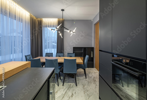 Modern grey and wooden interior of kitchen in luxury private house.