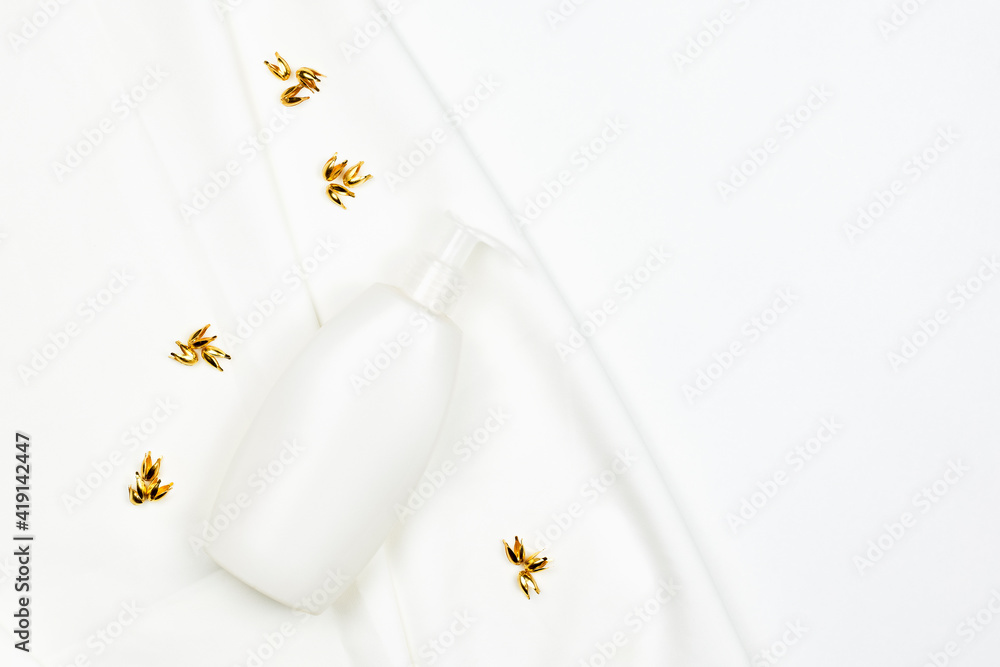 White cosmetics bottle on white textile. White jar of cosmetic essential or bath accessories. Face and body care concept White cosmetics bottle on white textile. White jar of cosmetic essential or bath accessories. Face and body care concept