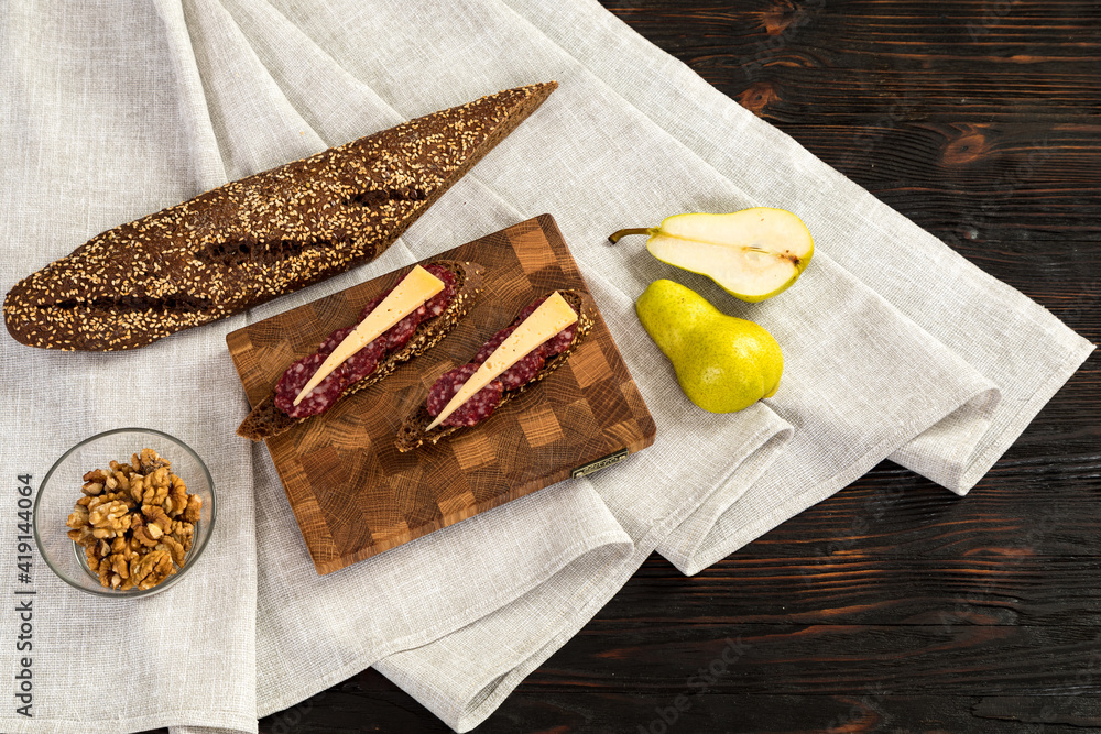 Sausage and cheese sandwiches on a wooden cutting board