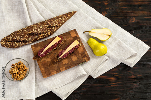 Obraz na płótnie Sausage and cheese sandwiches on a wooden cutting board w salonie
