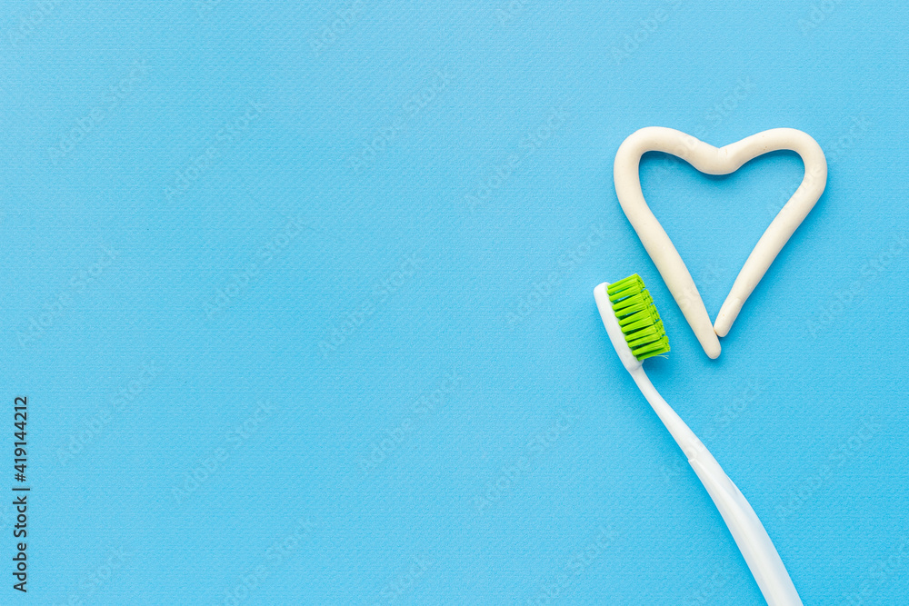 Heart shape of toothpaste with toothbrush, top view. Oral care and hygiene
