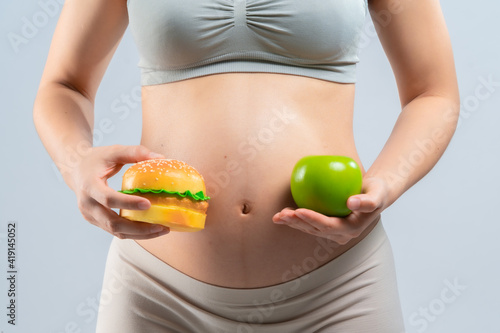 Asian pregnant woman choose healthy food or junk food