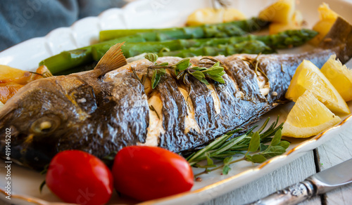 Roasted dorado fish with herbs and vegetables , healthy food