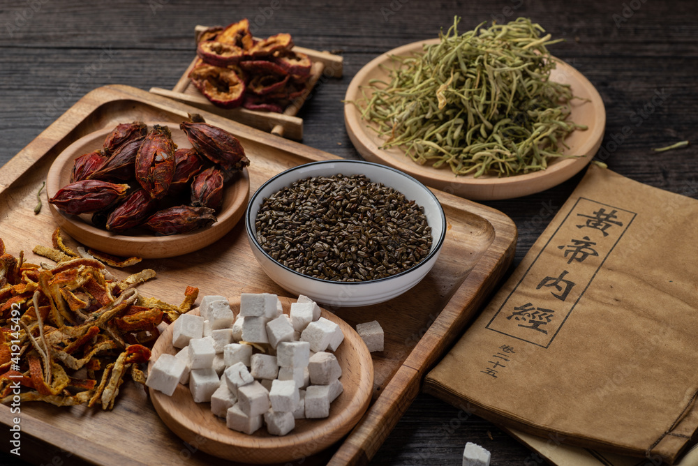 Ancient Chinese medicine books and herbs on the table.English translation:Emperor's Internal Classic Ancient Chinese medicine books and herbs on the table.English translation:Emperor's Internal Classic