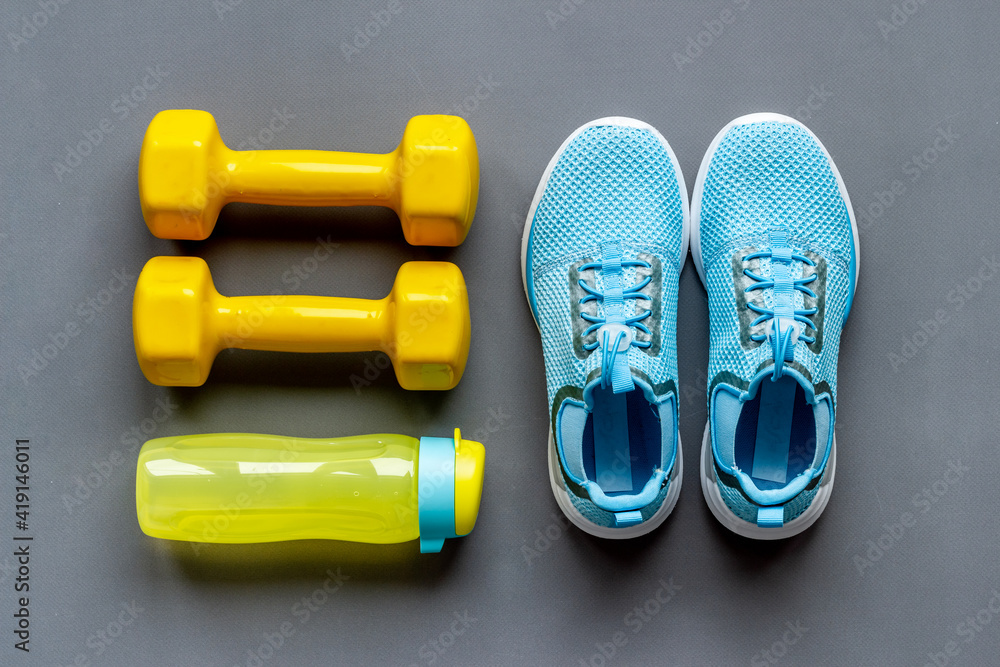 Top view of fitness accessories with dumbbells and sneakers - obrazy, fototapety, plakaty 