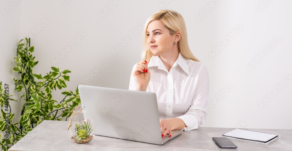 Happy Young Beautiful Woman Using Laptop, Indoors on white wall background Happy Young Beautiful Woman Using Laptop, Indoors on white wall background