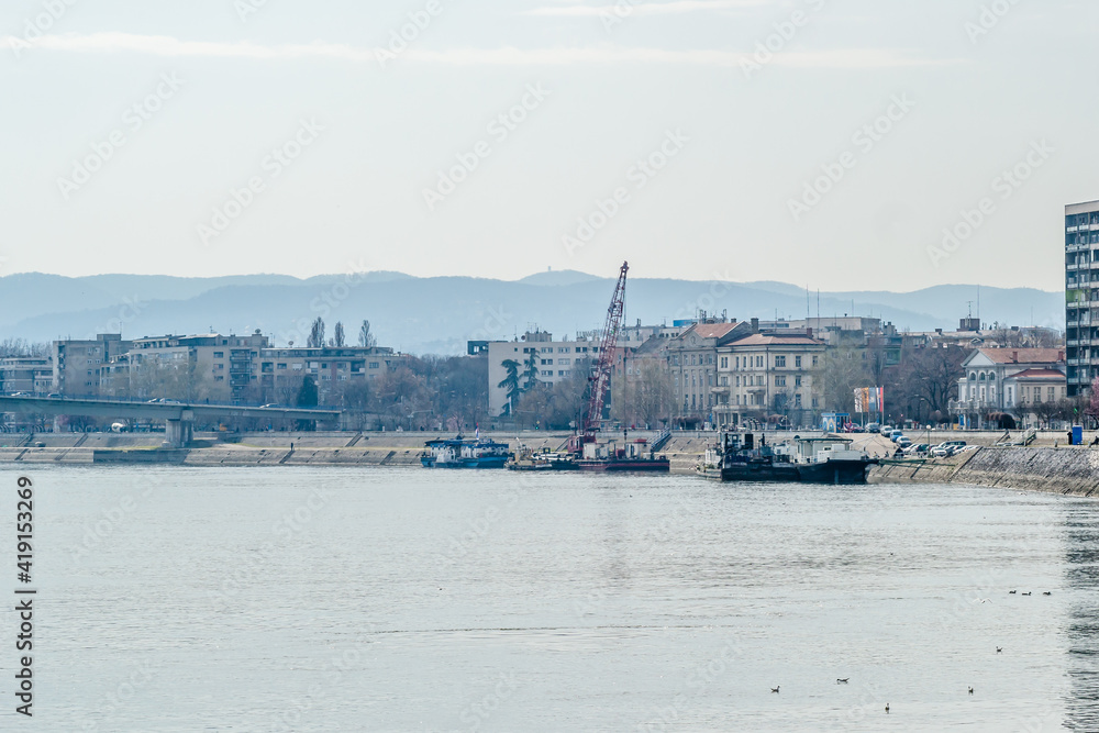 Novi Sad, Serbia - March 5, 2021: Working machine anchored, on the promenade Belgrade Quay, on the banks of the Danube River, in Novi Sad. 