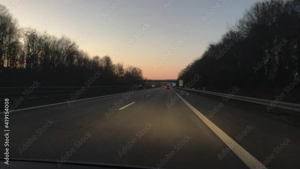 Driving on a typical German autobahn during sunset. Driving past a police car with blinking blue lights. Plate for green screen. Driving on a typical German autobahn during sunset. Driving past a police car with blinking blue lights. Plate for green screen.