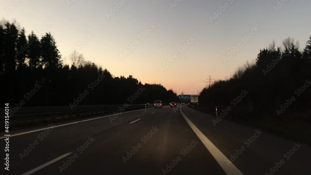 Car driving on the German Autobahn A7 with medium speed on a sunny evening. Beautiful sky in the background. Cars passing by, changing the lane. Plate for greenscreen. Car driving on the German Autobahn A7 with medium speed on a sunny evening. Beautiful sky in the background. Cars passing by, changing the lane. Plate for greenscreen.