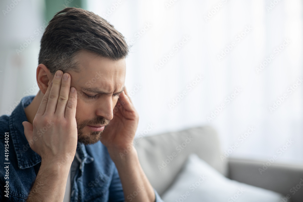 Closeup of middle-aged man suffering from headache Closeup of middle-aged man suffering from headache