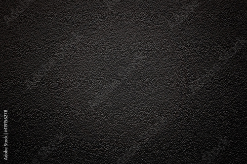 Dark background with fine texture and vignetting with emphasis on the center. An empty flat and clean surface for information. Advertising backdrop