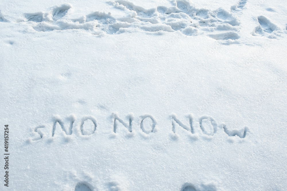Word of snow and three times in large letters NO written on a snowbank. Spring anticipation concept. Copy space. Creative idea. Word of snow and three times in large letters NO written on a snowbank. Spring anticipation concept. Copy space. Creative idea.