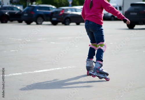 Wallpaper Mural A teenage girl is rollerblading on the playground. View of the child from the back, without a face. Blurred focus, copying text Torontodigital.ca