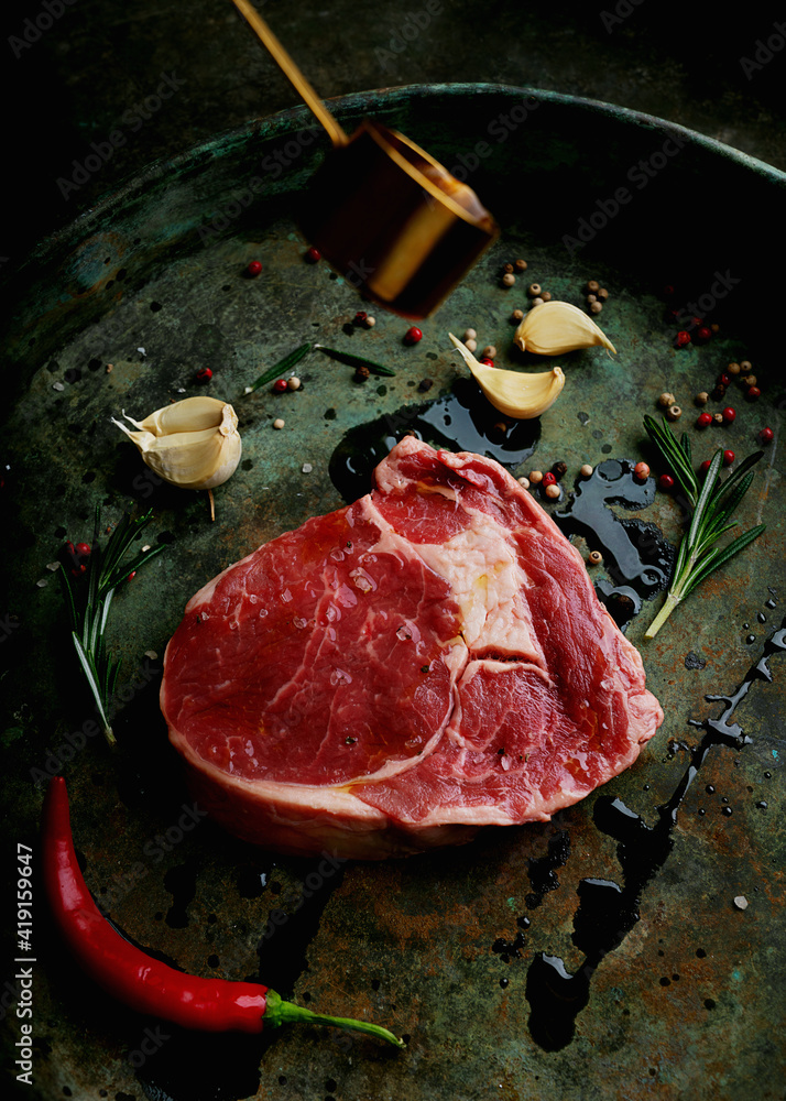 Raw dry aged rieye steak over rustic background