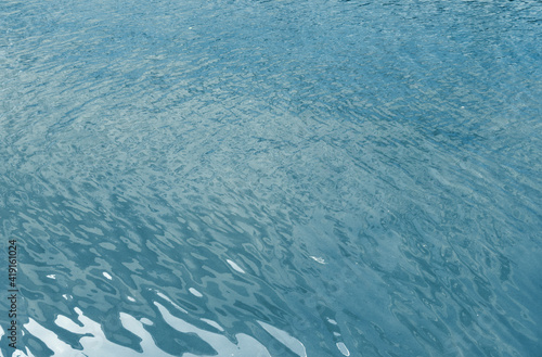 Water surface with ripples and sunlight reflections