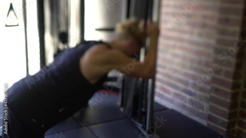Tattoo man muscles in home gym cable ab crunch