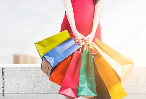 The woman carrying shopping bags standing