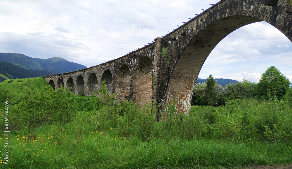 Old railway stone bridge or viaduct in mountains