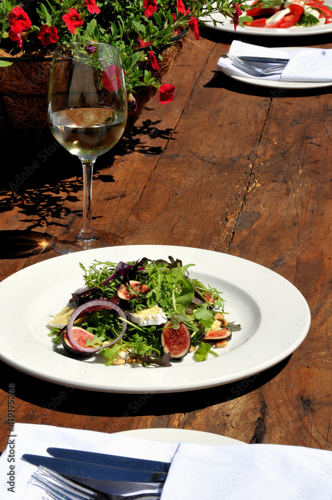 A earthy lunch of salads and wine on a rustic wooden table