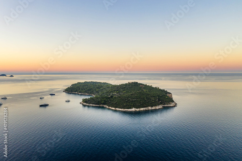 Aerial drone shot of Otok Lokrum in Adriatic sea by Dubrovnik old town port in Croatia summer before sunrise
