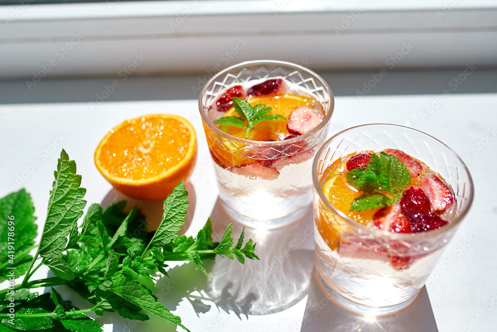 Summer cocktail with strawberry, orange and mint in glass Summer cocktail with strawberry, orange and mint in glass
