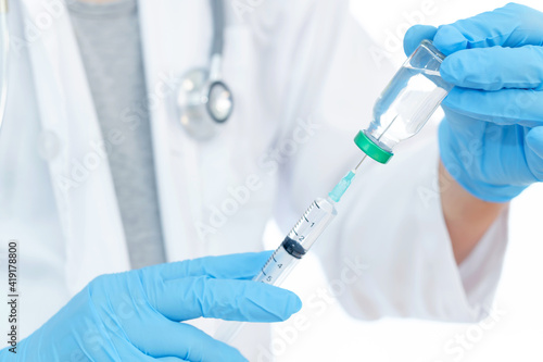 Close up vaccines fight against virus, doctor or scientist in laboratory holding a syringe with liquid vaccines.