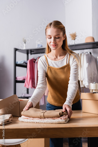 Young successful businesswoman collecting order in clothes boutique