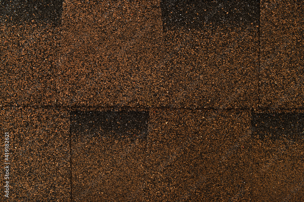 Fototapeta premium brown, grainy background of bituminous roofing tiles, top view