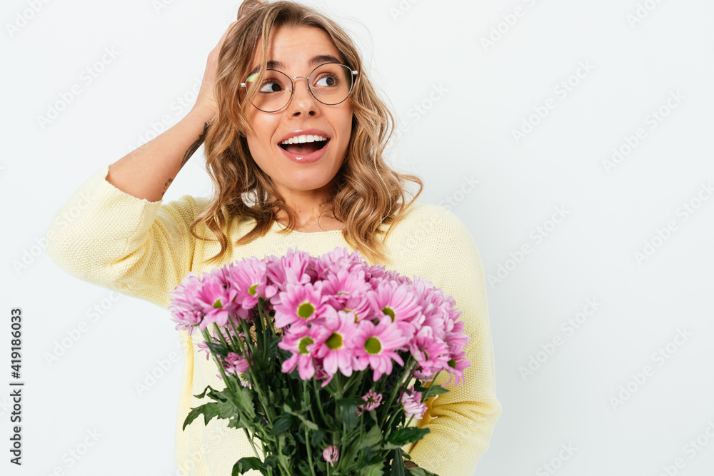 Amazed happy young woman wearing eyeglasses holding bouquet