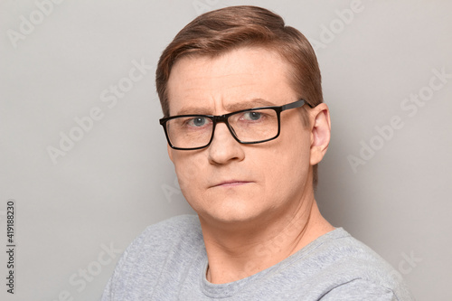 Portrait of mature man with glasses with serious expression on face © Andrei Korzhyts