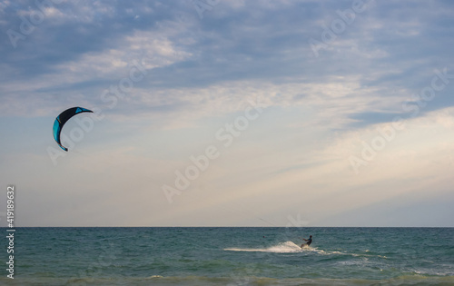 kitesurfer rides a kite-surf on waves of the sea