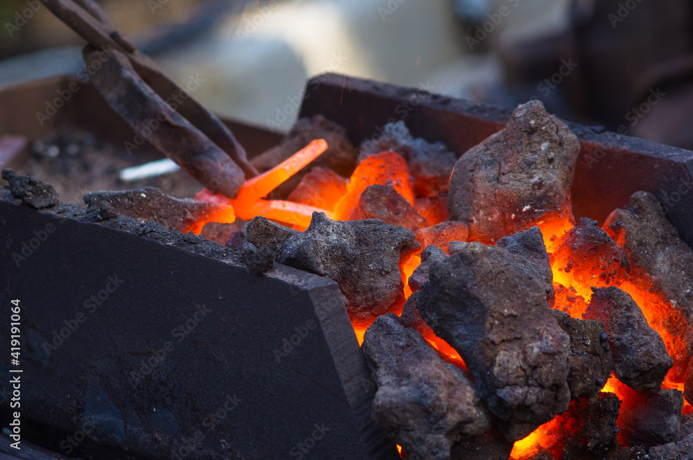 blacksmith furnace with burning coals, tools, and glowing hot metal workpieces blacksmith furnace with burning coals, tools, and glowing hot metal workpieces