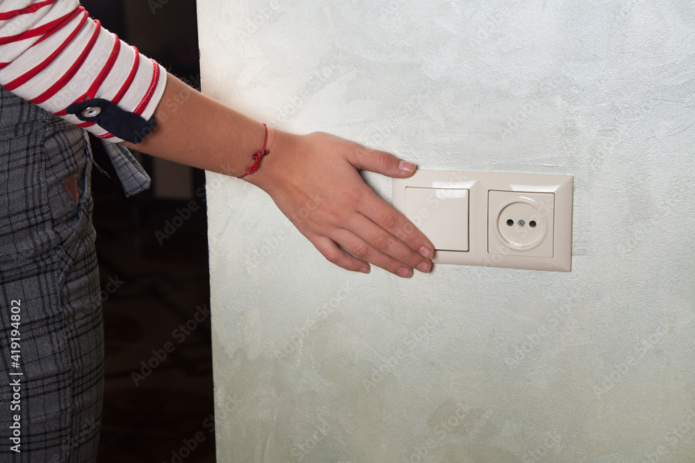  On or off light switch. Woman hand.
