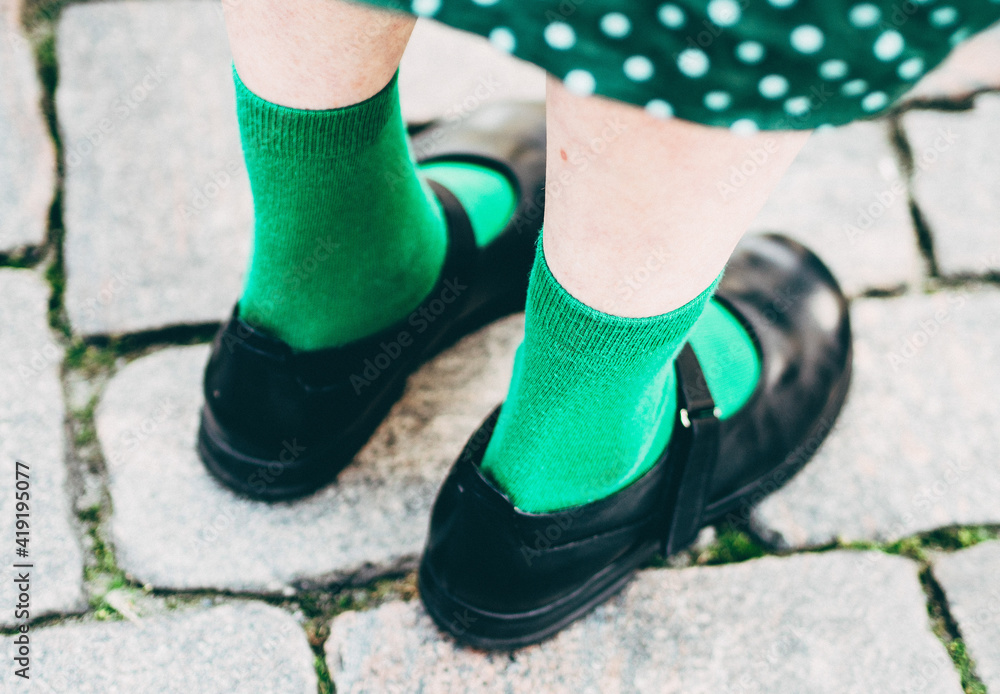 lower section of woman in black shoes and green socks