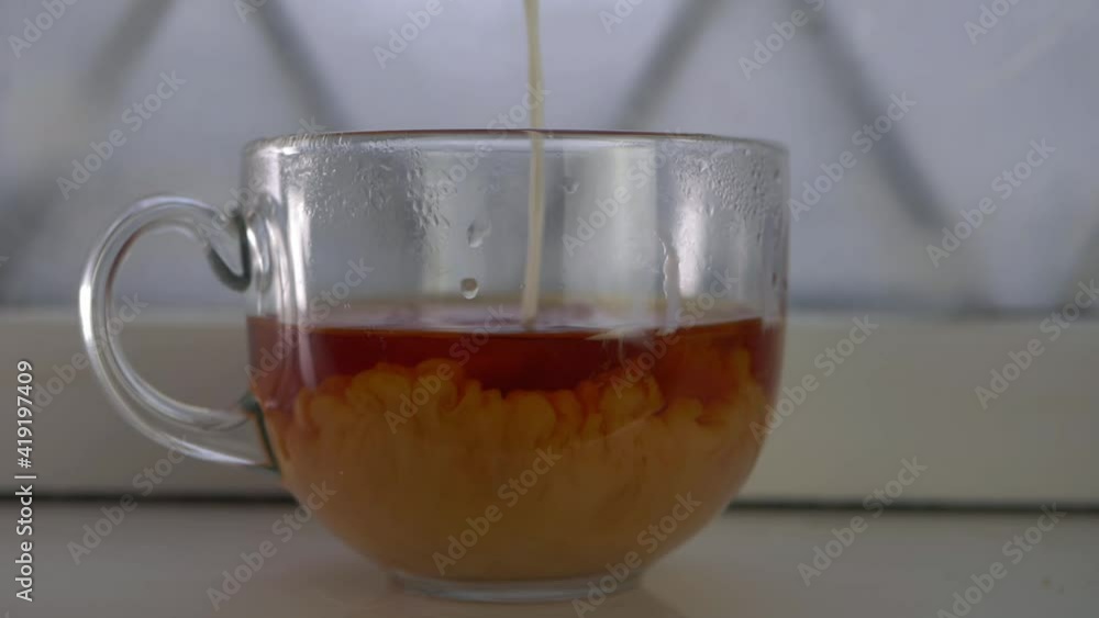 Pouring milk into a mug of freshly made tea Pouring milk into a mug of freshly made tea