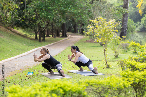 Fototapeta Naklejka Na Ścianę i Meble -  two women practicing yoga in a park, Barueri, São Paulo, Brazil