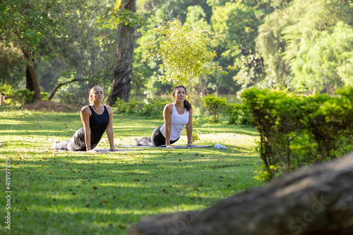 Fototapeta Naklejka Na Ścianę i Meble -  two women practicing yoga in a park, Barueri, São Paulo, Brazil