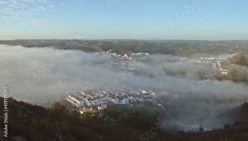 Vista panor  mica del amanecer en dos peque  os pueblos fronterizos envueltos en la niebla del r  o Guadiana  Sanl  car de Guadiana  Espa  a  Alcoutim  Portugal .
