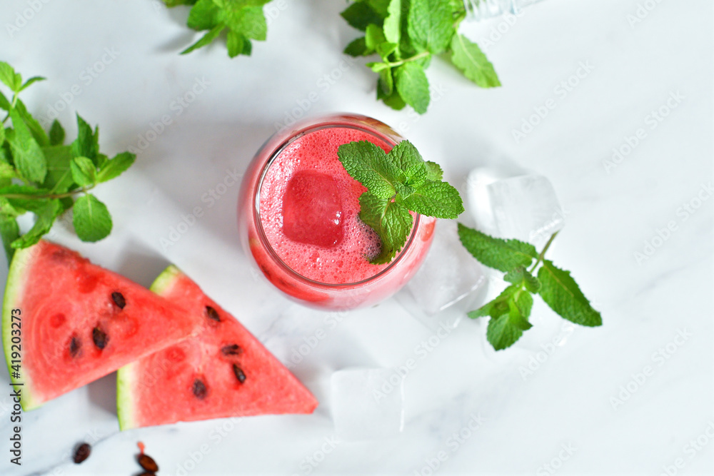 Fresh watermelon juice with mint and ice in the glass on white table.Sweet summer dessert, smoothie,cocktail healthy food concept, close up.Summertime. Copy spase. Selective focus Fresh watermelon juice with mint and ice in the glass on white table.Sweet summer dessert, smoothie,cocktail healthy food concept, close up.Summertime. Copy spase. Selective focus