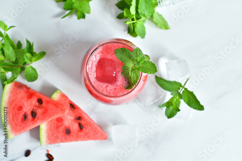 Fresh watermelon juice with mint and ice in the glass on white table.Sweet summer dessert, smoothie,cocktail healthy food concept, close up.Summertime. Copy spase. Selective focus