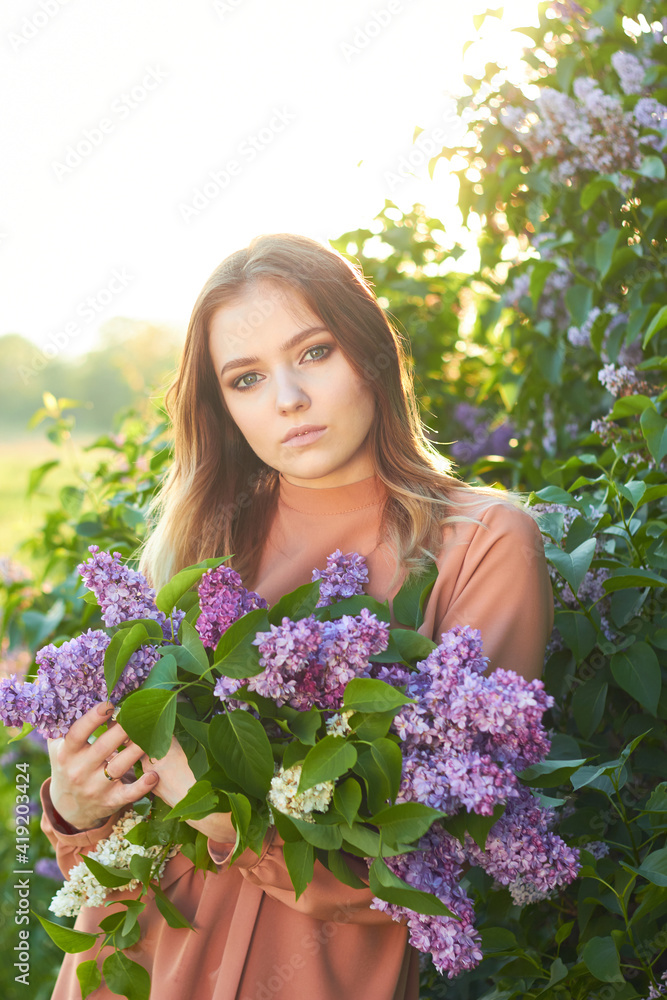 Young beautiful girl with a bouquet of lilacs. Walk in the fresh air. Freshness, spring and flowers concept. Young beautiful girl with a bouquet of lilacs. Walk in the fresh air. Freshness, spring and flowers concept.