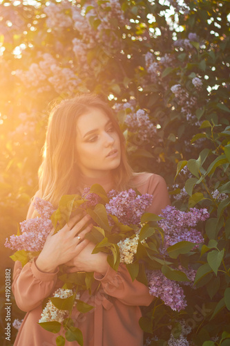 Young beautiful girl with a bouquet of lilacs. Walk in the fresh air. Freshness  spring and flowers concept.