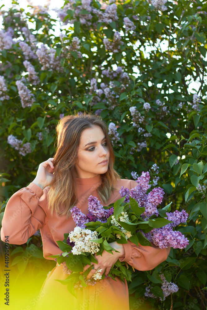 Young beautiful girl with a bouquet of lilacs. Walk in the fresh air. Freshness, spring and flowers concept. Young beautiful girl with a bouquet of lilacs. Walk in the fresh air. Freshness, spring and flowers concept.