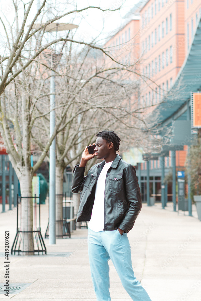 Fototapeta premium joven afro emprendedor en la ciudad de lyon francia hablando con su smartphone