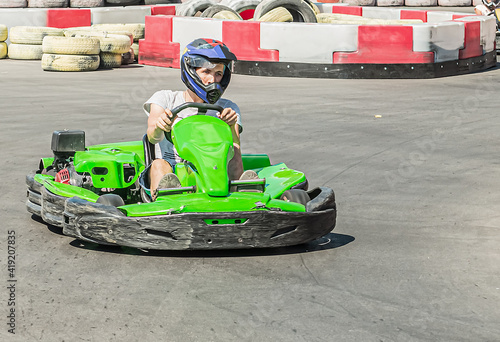 A special children's go kart track on which a young man rides a sports car