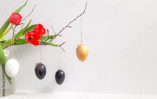Easter composition with and red tulips and eggs on a white background. 