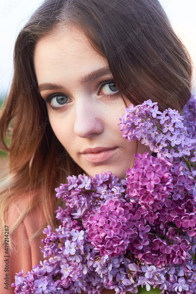 Young beautiful girl with a bouquet of lilacs. Walk in the fresh air. Freshness, spring and flowers concept. Young beautiful girl with a bouquet of lilacs. Walk in the fresh air. Freshness, spring and flowers concept.