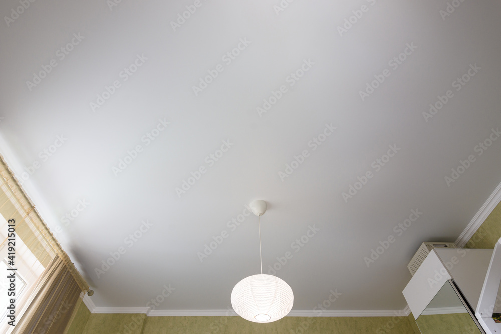 Stretch white matte ceiling close-up in a bedroom