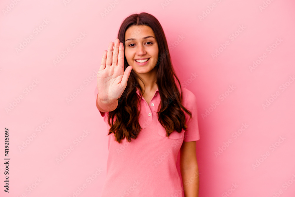 Young Indian woman isolated on pink background smiling cheerful showing number five with fingers.